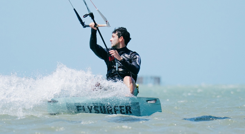 Instructor de kitesurf pilotando la cometa durante una clase en la playa de Icaraizinho