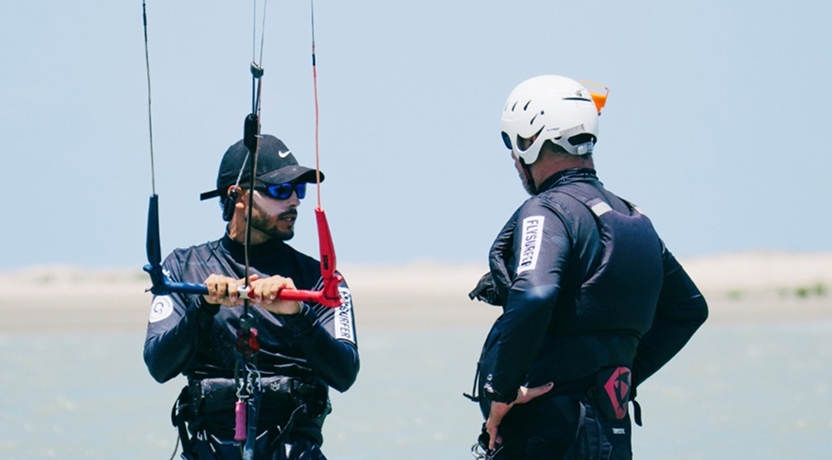 Instructor orientando a un alumno de kitesurf antes de entrar al mar