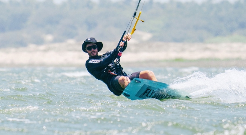 Practicante de kitesurf realizando una maniobra en el agua durante una clase en Icaraizinho