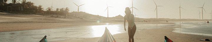 Practicante caminando en la playa de Icaraizinho con cometas al fondo