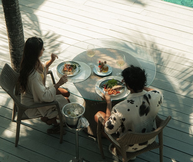 People eating at a table next to the pool